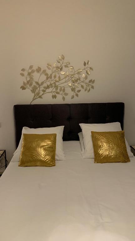 un letto con due cuscini dorati sopra di Appartements des 2 Têtes a Colmar