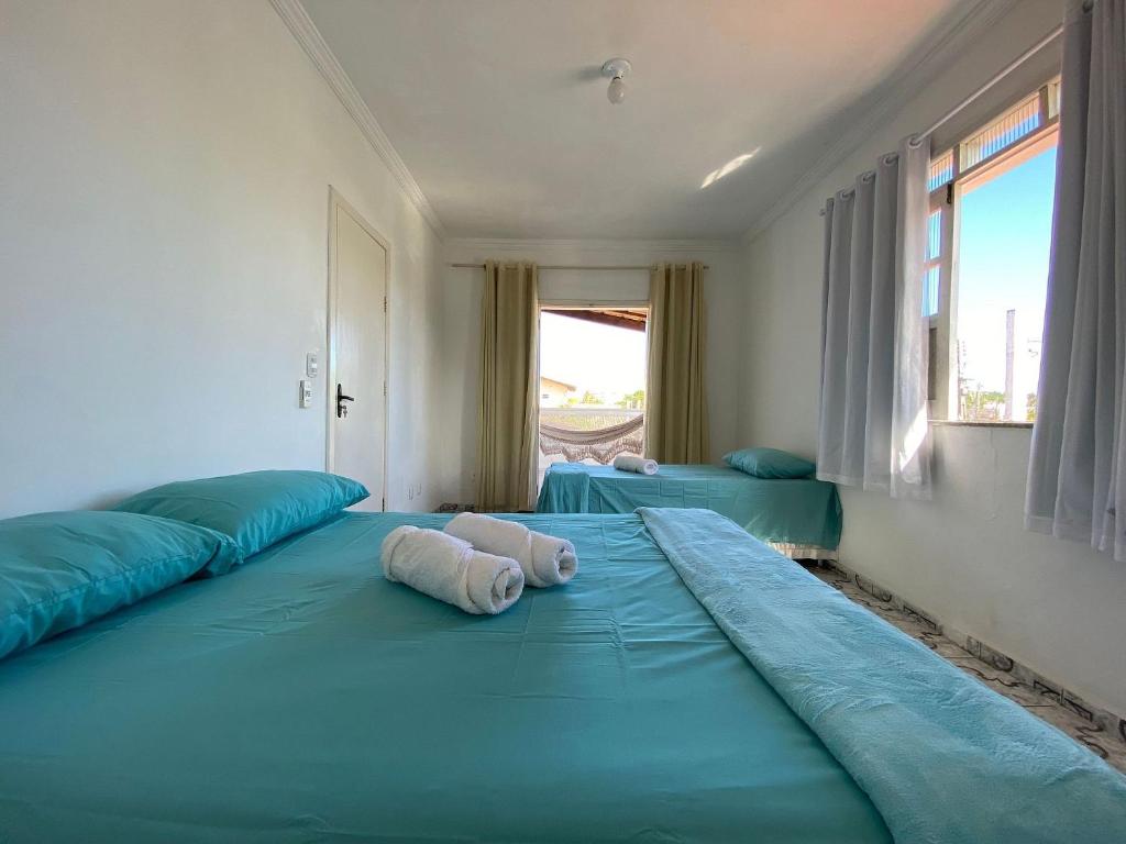 Duas camas grandes num quarto com lençóis azuis em Kalug - Guest House com 3 quartos em Condomínio na Praia dos Milionários em Ilhéus