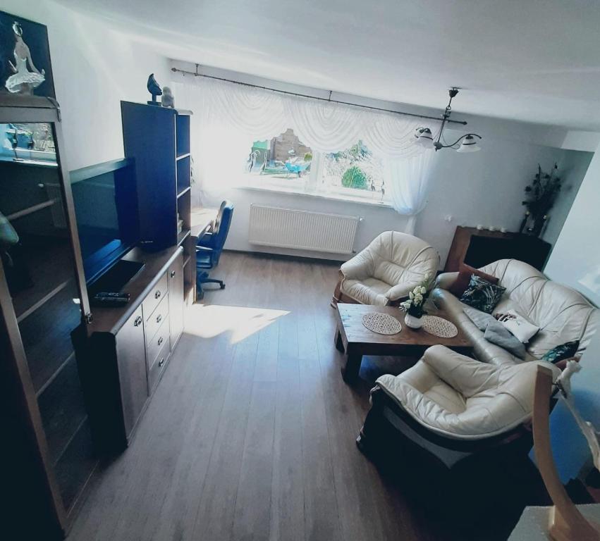 ein Wohnzimmer mit 2 Sofas und einem TV in der Unterkunft Apartament przy plaży free parking in Złotów