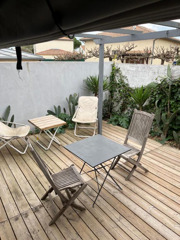 a table and two chairs and an umbrella on a deck at Studio indépendant très calme in Saint-Jean-de-Védas