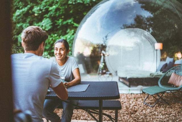 Un uomo e una donna seduti a un tavolo di Bubble-Tent Elzach inklusive Hot Tube Badefass a Elzach