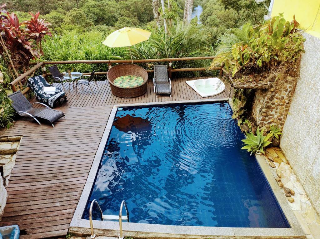 a small swimming pool on a wooden deck at Pousada Bella Vista in Visconde De Maua
