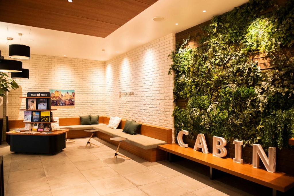 a lobby with a large green wall at First Cabin Ichigaya in Tokyo