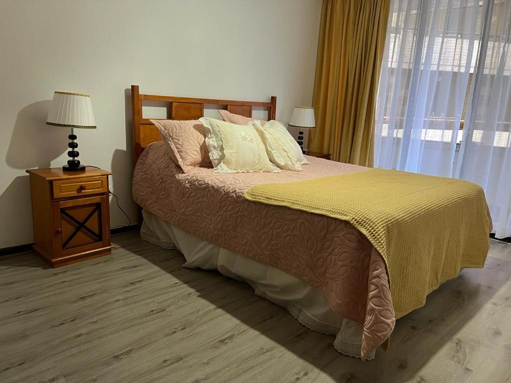 1 dormitorio con 1 cama y 1 mesa con lámpara en Departamentos Providencia J&M en Santiago