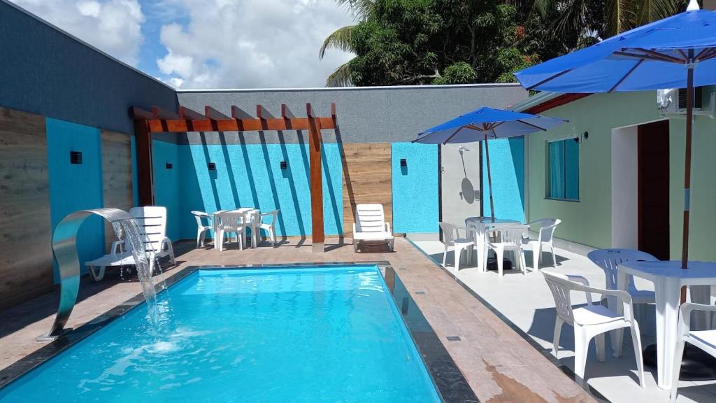 einen Pool mit Stühlen, Tischen und Sonnenschirmen in der Unterkunft PRADO-CARIBE DO NORDESTE: CASA TEMPORADA!!! in Prado