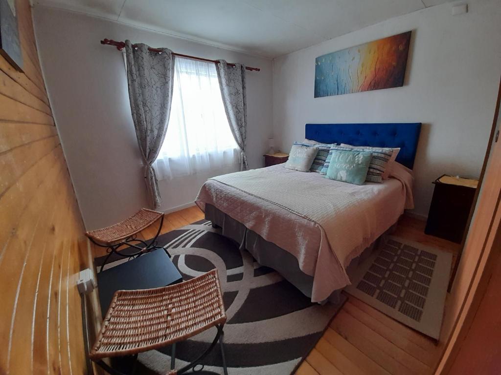 1 Schlafzimmer mit einem Bett, 2 Stühlen und einem Fenster in der Unterkunft Descanso Sureño Hospedaje in Valdivia