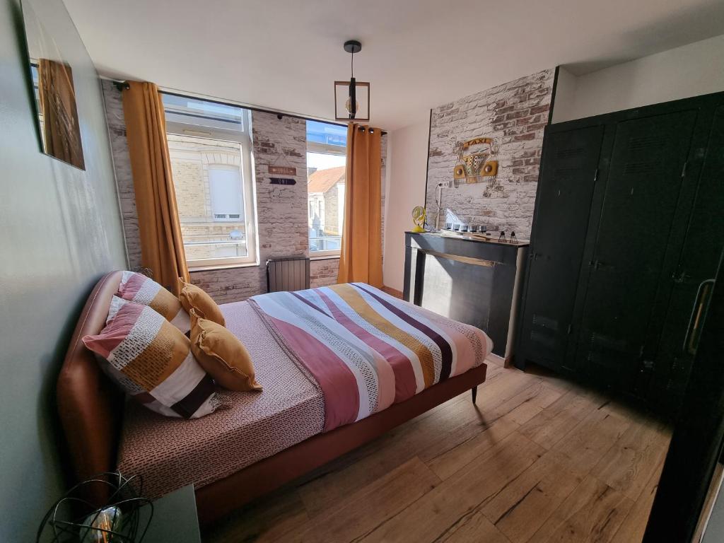 a small bedroom with a bed and a window at comme un air de chez soi in Calais