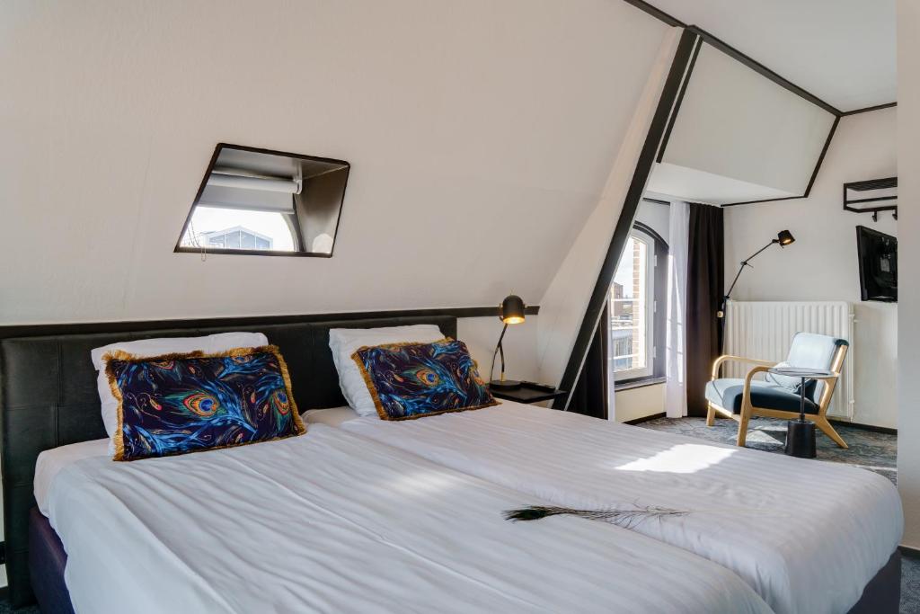 ein Schlafzimmer mit einem großen Bett mit zwei Kissen in der Unterkunft Hotel Pauw in Nijmegen
