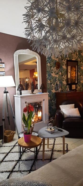 a living room with a fireplace and a mirror at Maison cocconing proche Reims in Boult-sur-Suippe