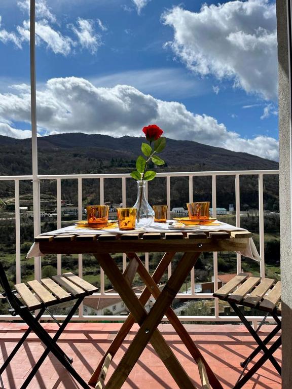 a table with a flower in a vase on a deck at El Rinconcito de Bejar in Béjar
