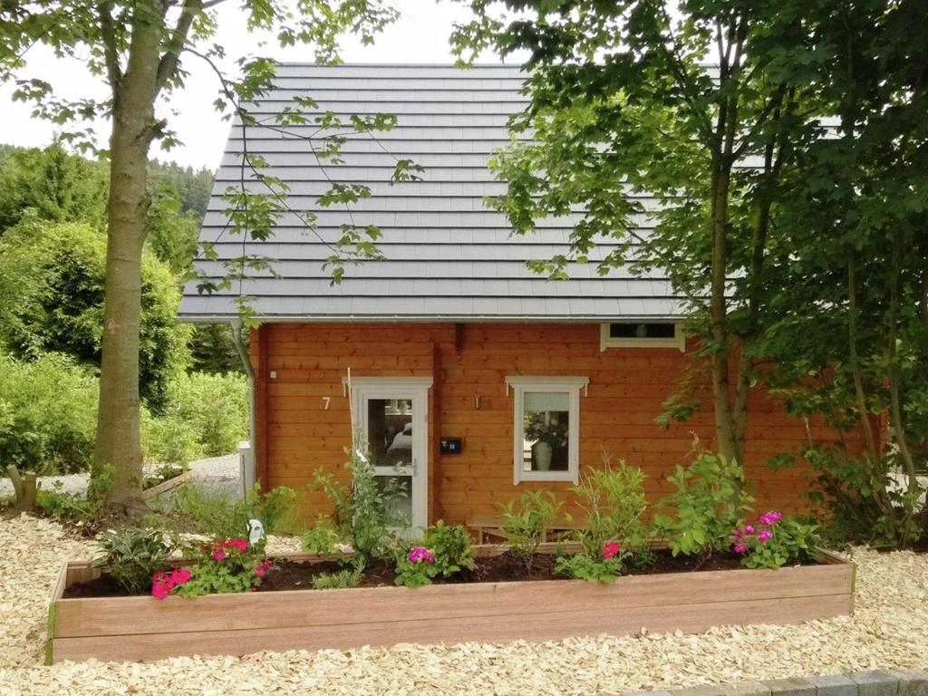 uma pequena casa no meio de um jardim em Wooden house with sauna in K stelberg em Medebach