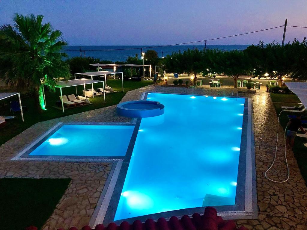 basen z niebieskimi światłami na terenie ośrodka w obiekcie Glyfa Beach Hotel w mieście Vartholomión