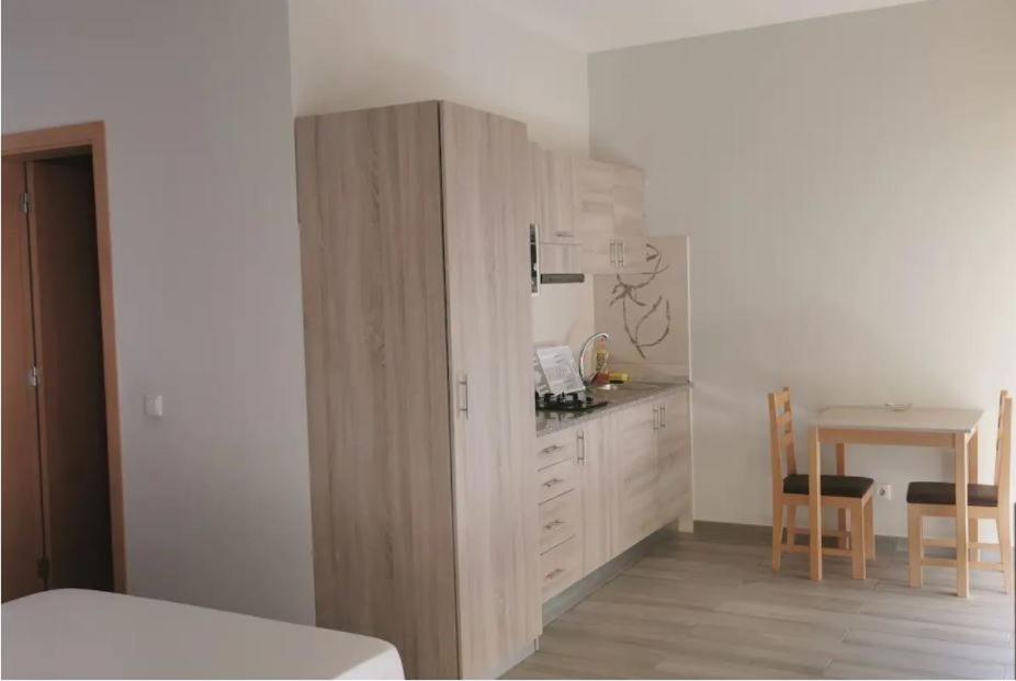 a room with a kitchen with a counter and a table at Ellen Apartamentos in Espargos