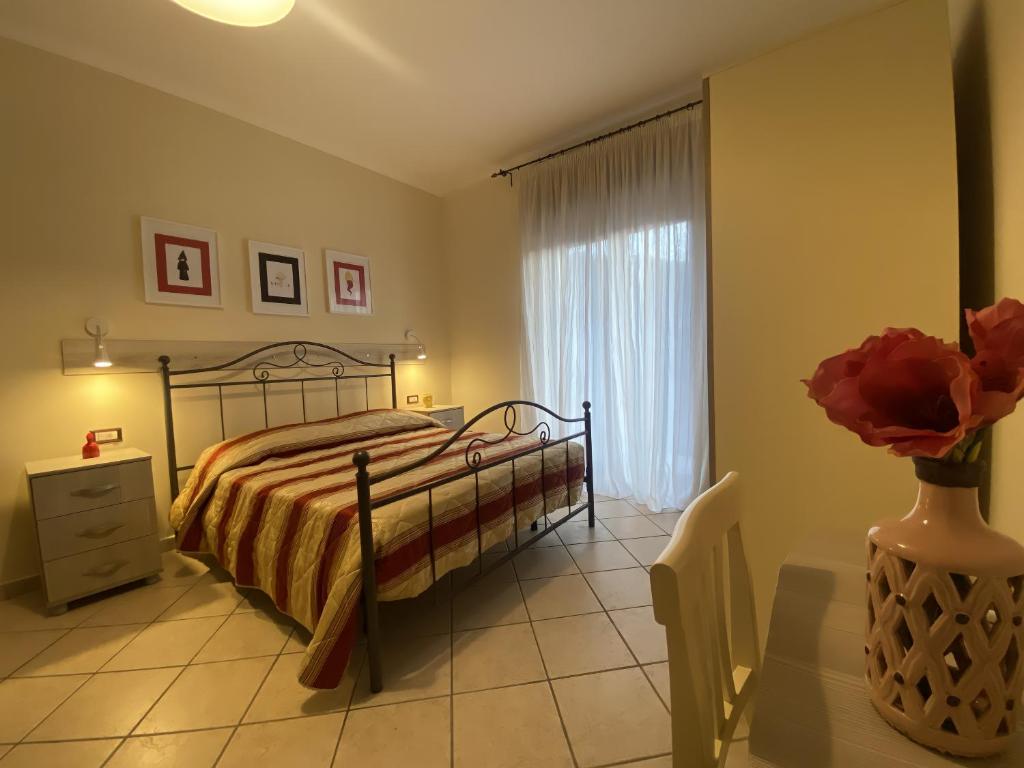 a bedroom with a bed and a vase of flowers at The Reef Apartment in Sorrento