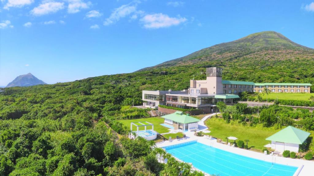 an aerial view of the resort with a mountain in the background at Hachijo View Hotel in Hachijo