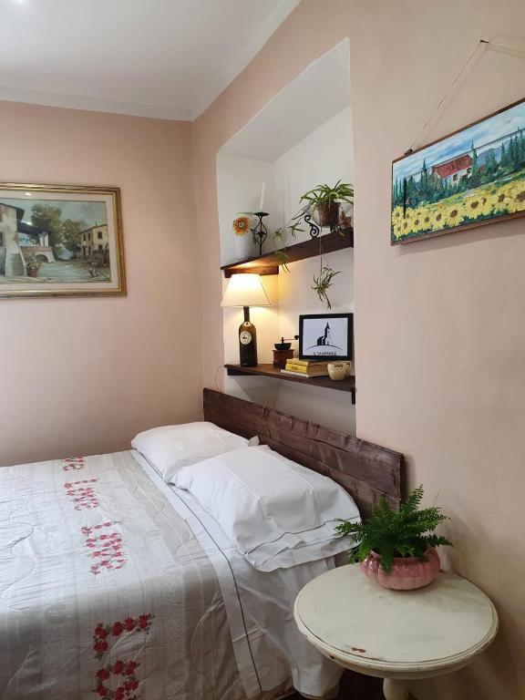 ein Schlafzimmer mit einem Bett und einem Tisch darin in der Unterkunft Il campanile in Laterina