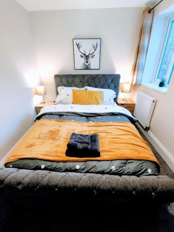 a bedroom with a large bed with an orange blanket at Crystal Suite 2 -free private parking in North Shields