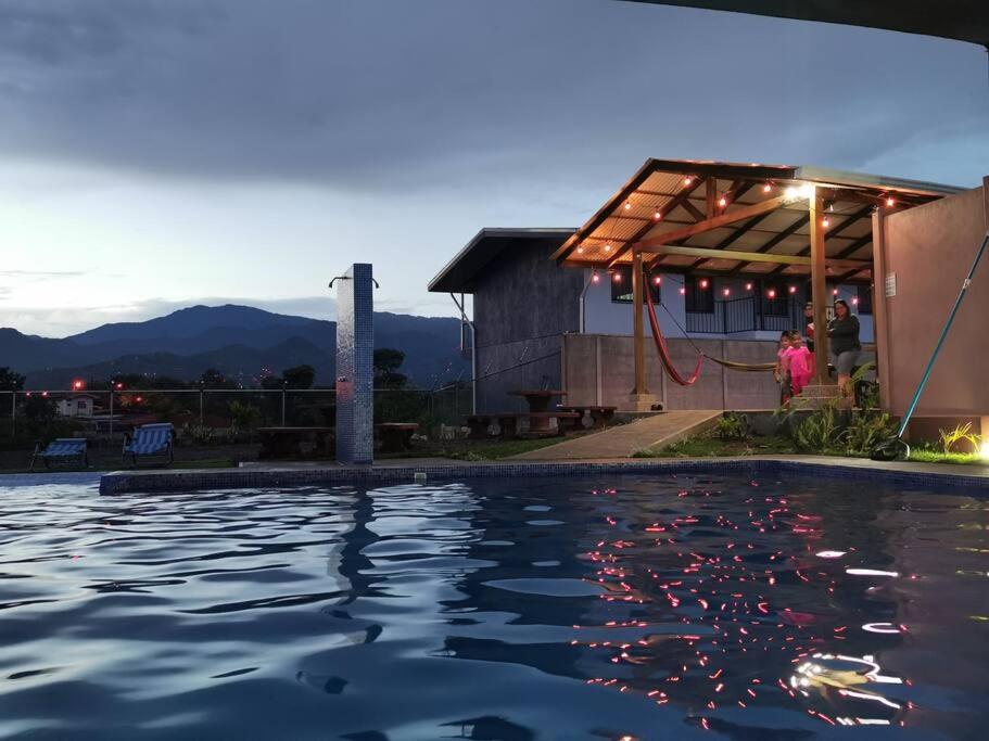une maison avec une piscine en face d'un bâtiment dans l'établissement Apartamento con dos habitaciones, à San Isidro de El General