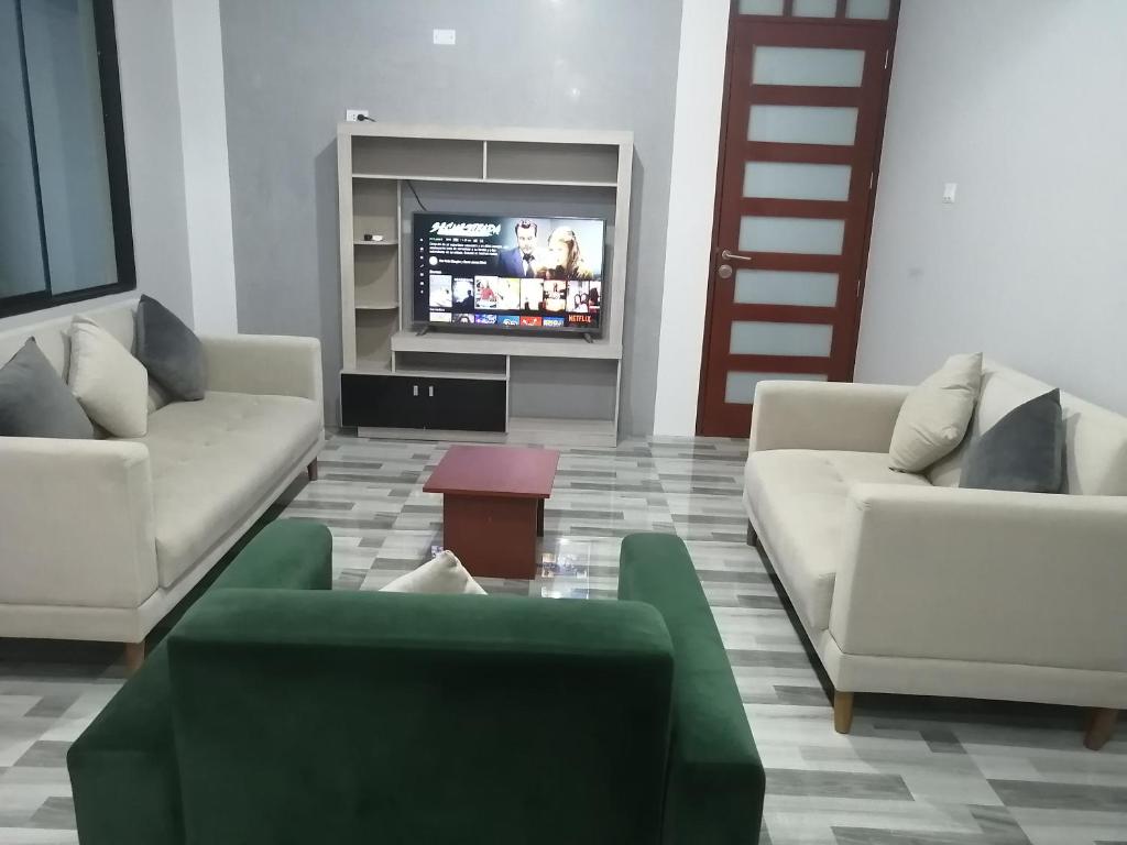 ein Wohnzimmer mit 2 Sofas und einem TV in der Unterkunft Apartamento familiar in Tarapoto