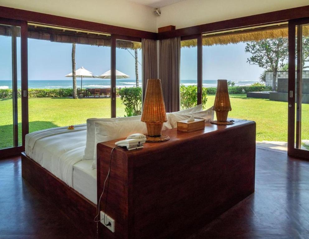 a bedroom with a bed with a view of the ocean at Sound of The Sea Villa in Canggu