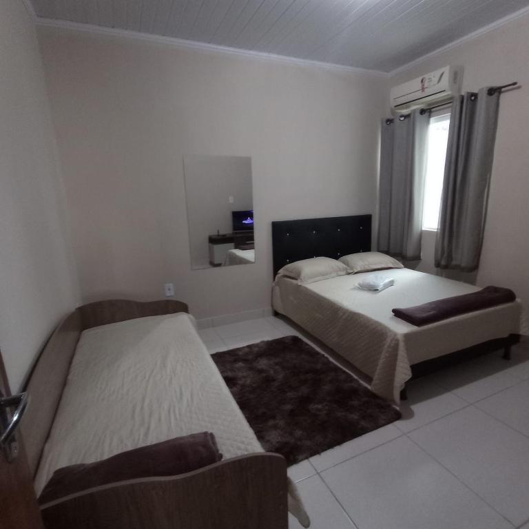 - une chambre avec 2 lits et une fenêtre dans l'établissement Acomodação barata., à Campos dos Goytacazes