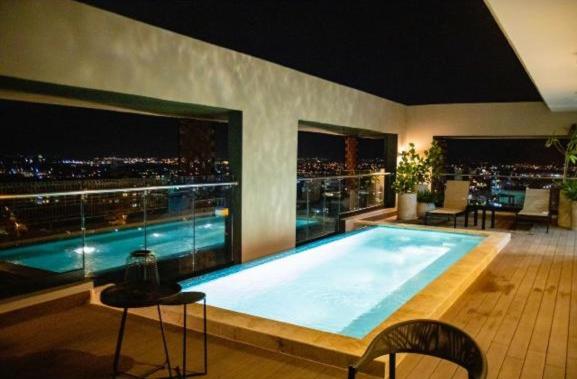 a large swimming pool on top of a building with a city skyline at Torre Rialto in Santiago de los Caballeros