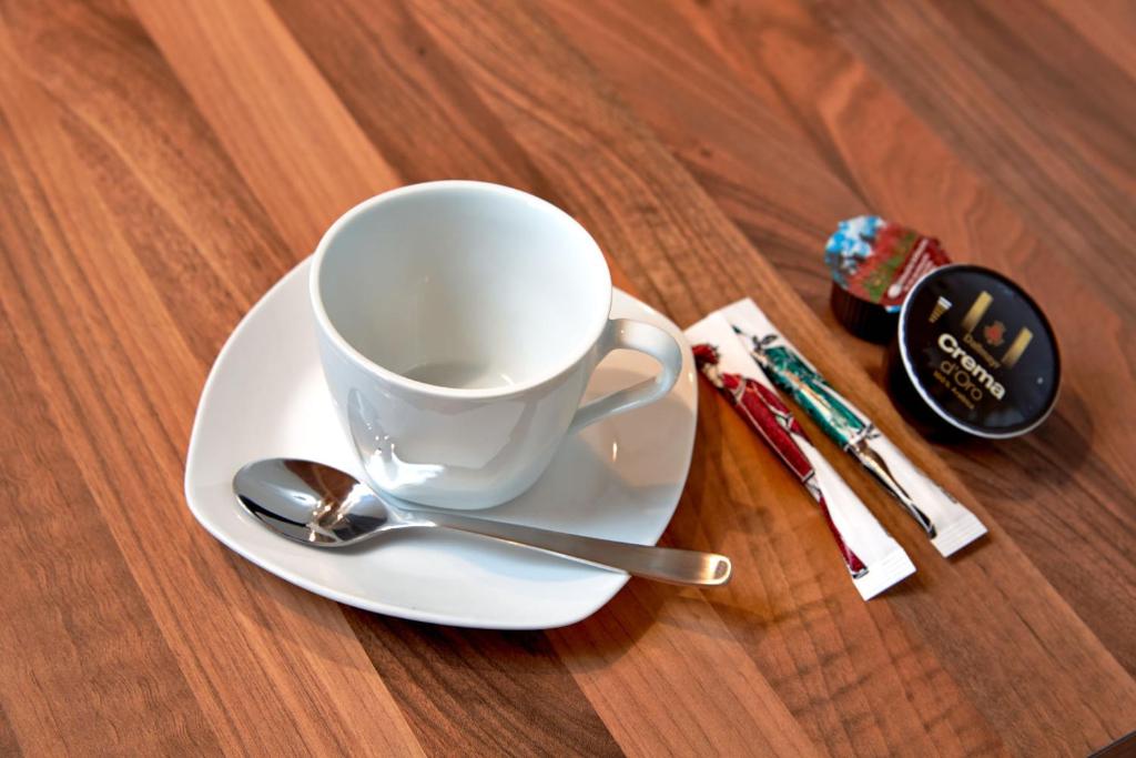 a coffee cup and spoon on a plate on a table at Kitz Mountain Living in Aurach bei Kitzbuhel