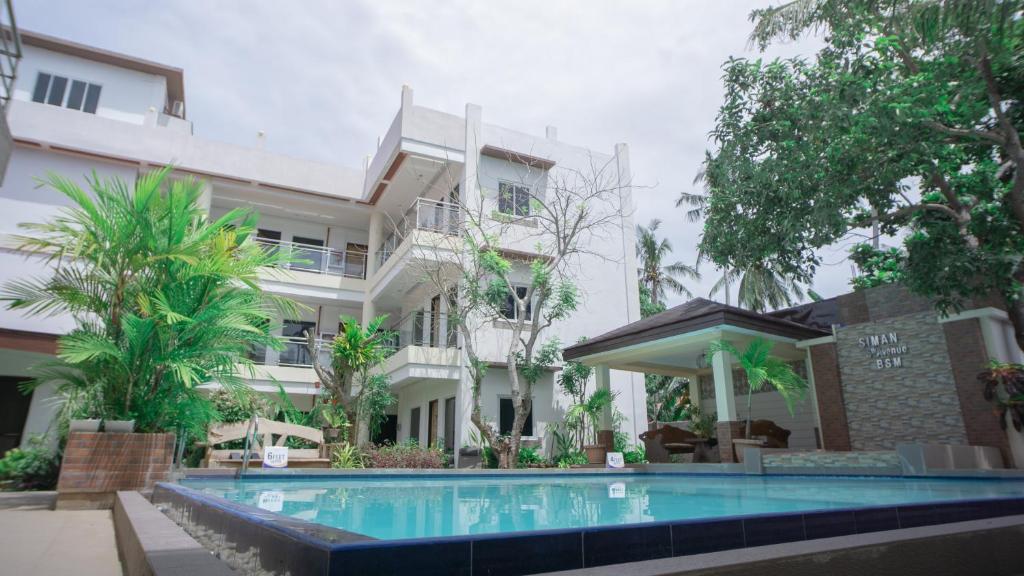 a hotel with a swimming pool in front of a building at Siman Panglao in Panglao