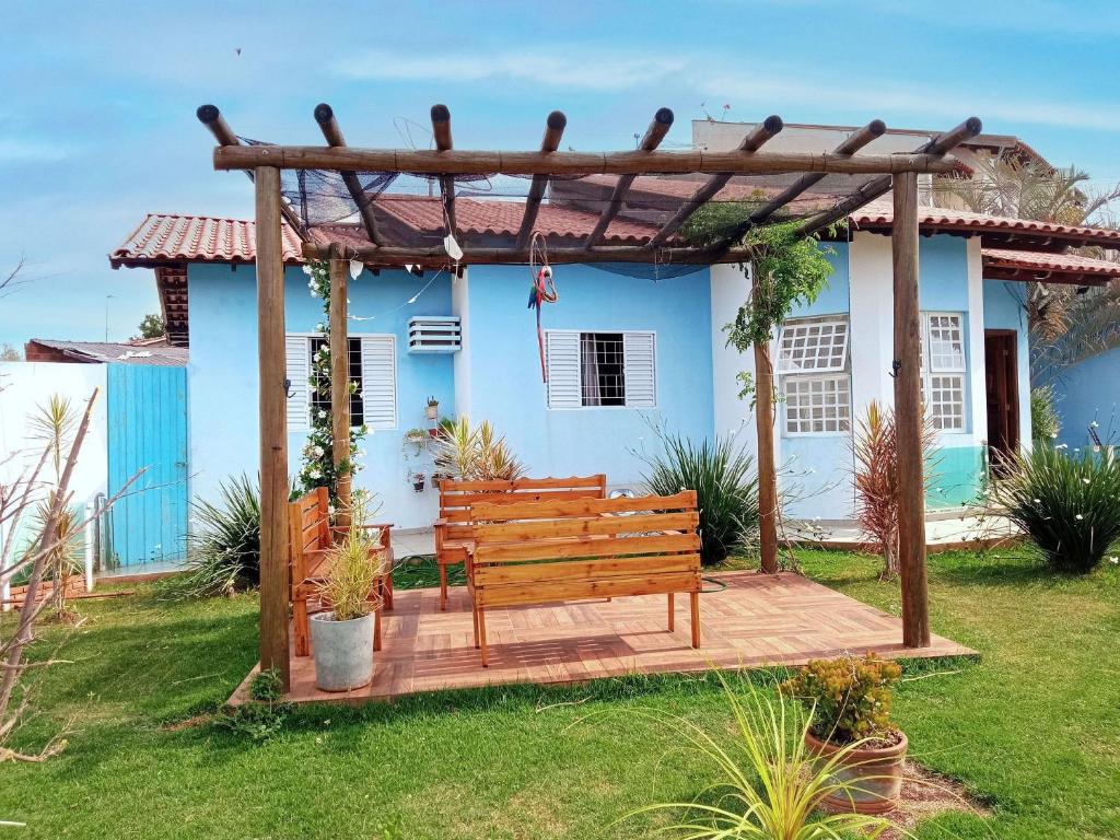 a wooden bench in front of a blue house at Casa Azul Antares 3 Quartos - Pet Friendly in Londrina