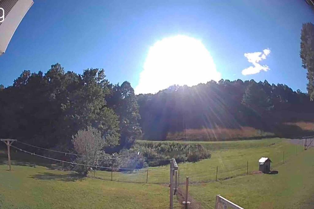 a field with a fence and the sun in the sky at Home in the Heart of W.V. Adventure Country! in Mount Hope