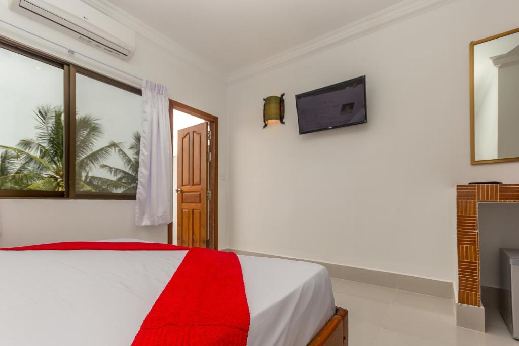 a white bedroom with a bed and a television at Blossoming Romduol Boutique in Siem Reap