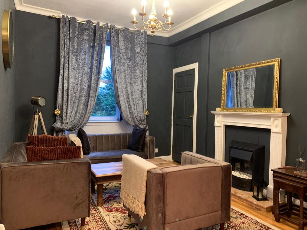 a living room with a couch and a fireplace at Glamours stylish Victorian apartment near city centre in Edinburgh