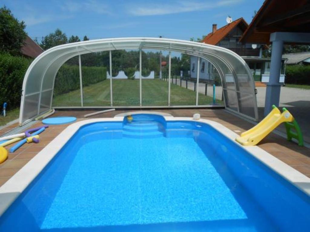 a swimming pool with a slide and a playground at schönes Ferienhaus mit grossen Pool 250 m vom Balaton in Balatonmáriafürdő