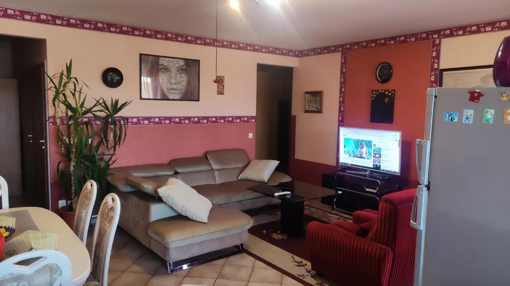 a living room with a couch and a tv at Tommy Apartman in Hajdúszoboszló