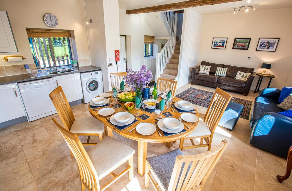 a kitchen and living room with a wooden table and chairs at Fabulous Listed Barn with the Best Valley View in Stanford on Teme