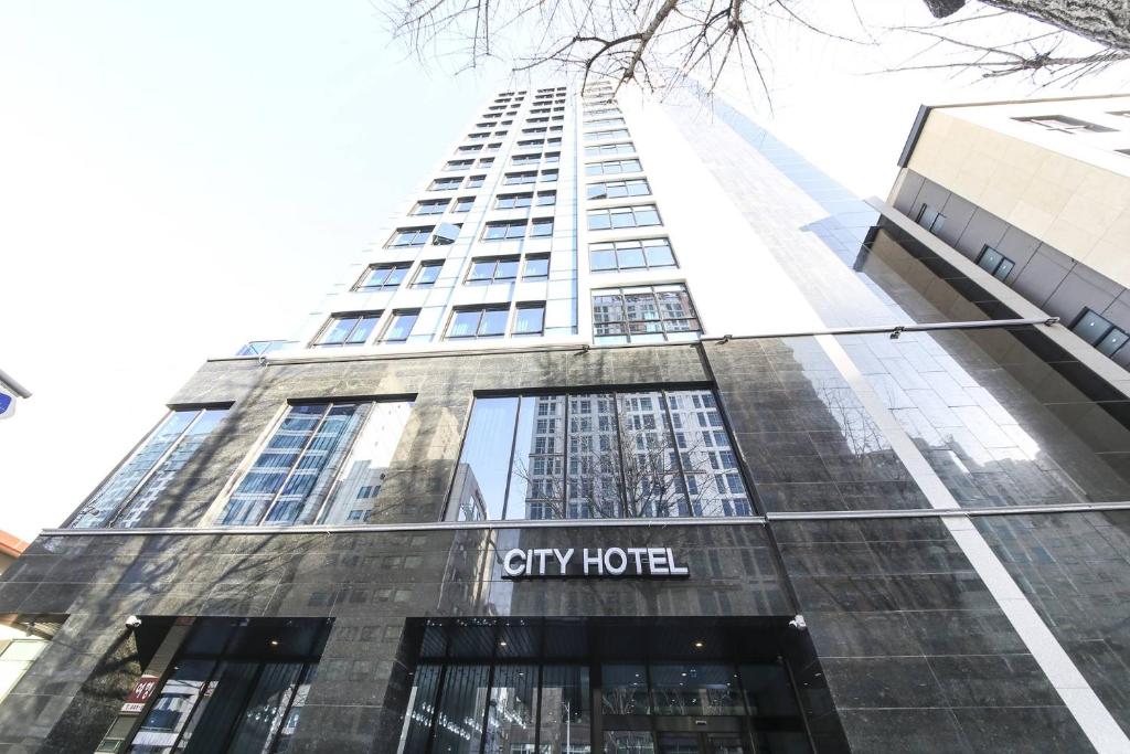 釜山的住宿－City Hotel the Busan Metro，一座高大的建筑,上面有城市酒店标志