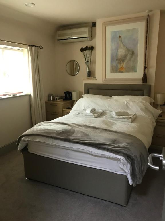 1 dormitorio con 1 cama con una foto de pollo en la pared en Highview Bed and Breakfast en Nailsworth
