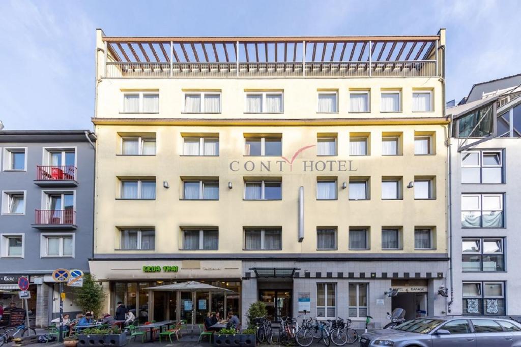 ein großes gelbes Gebäude mit einem Schild drauf in der Unterkunft Trip Inn Hotel Conti in Köln