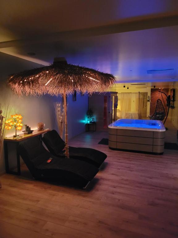 - un salon avec un lit et un grand parasol dans l'établissement Le relax, à La Louvière