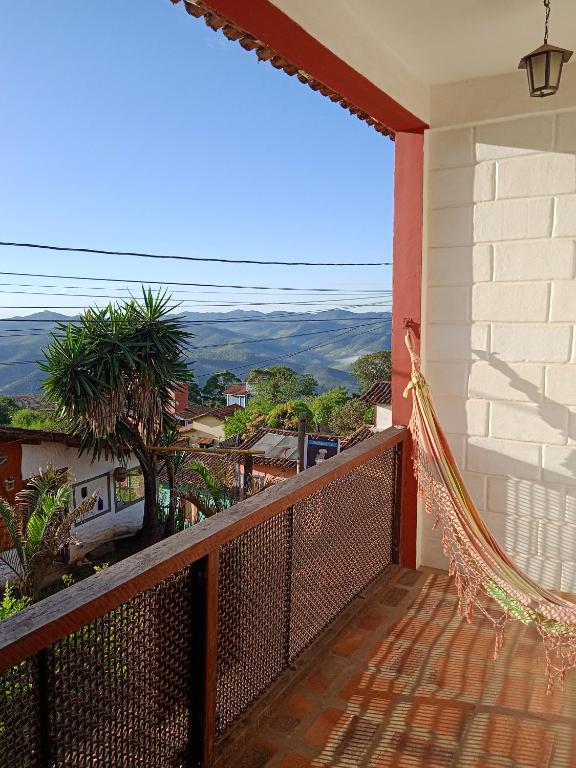 a balcony with a hammock on the side of a house at Pousada Fonte Viva in Lavras Novas