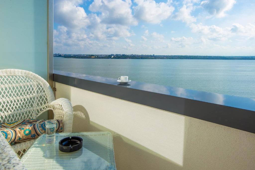 een tafel op een balkon met uitzicht op het water bij Derby Beach Mamaia. in Mamaia