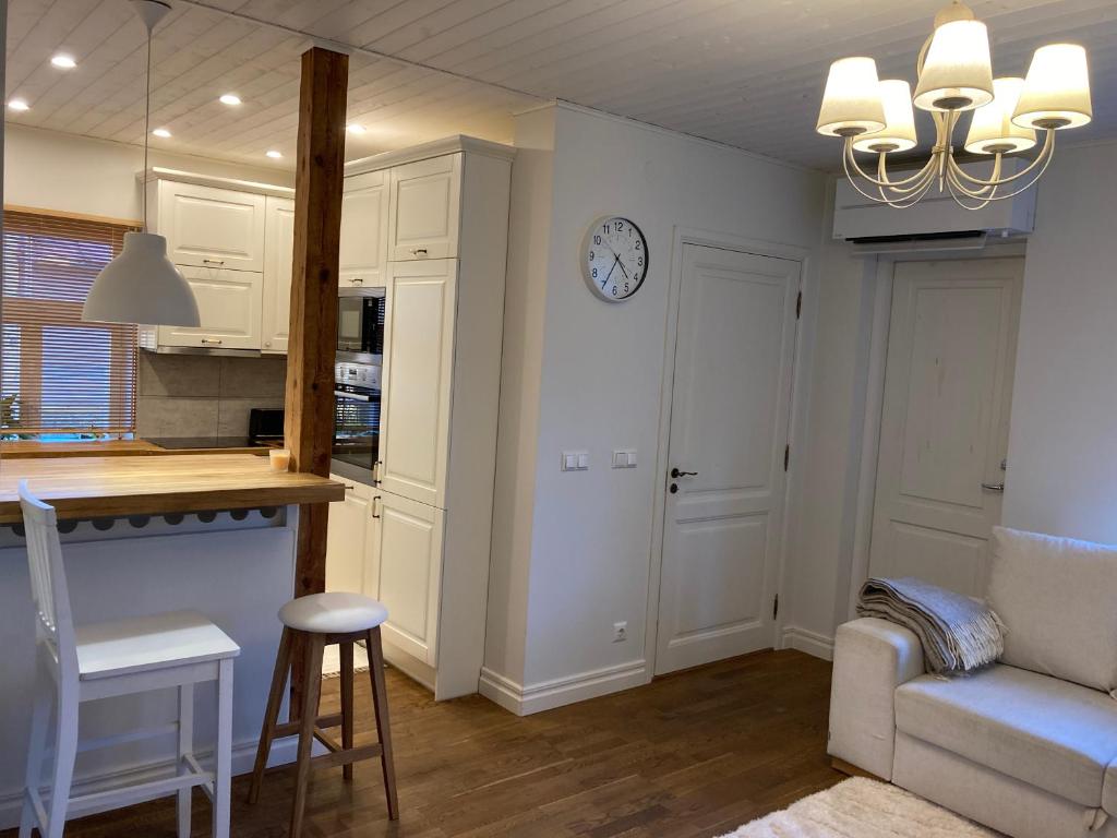a kitchen and living room with a clock on the wall at Lossi Apartment in Kuressaare