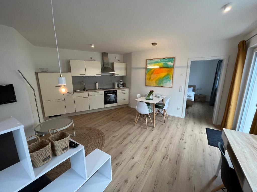 eine Küche und ein Wohnzimmer mit einem Tisch und Stühlen in der Unterkunft Moderne Ferienwohnung zum Wohlfühlen in Lindenberg im Allgäu
