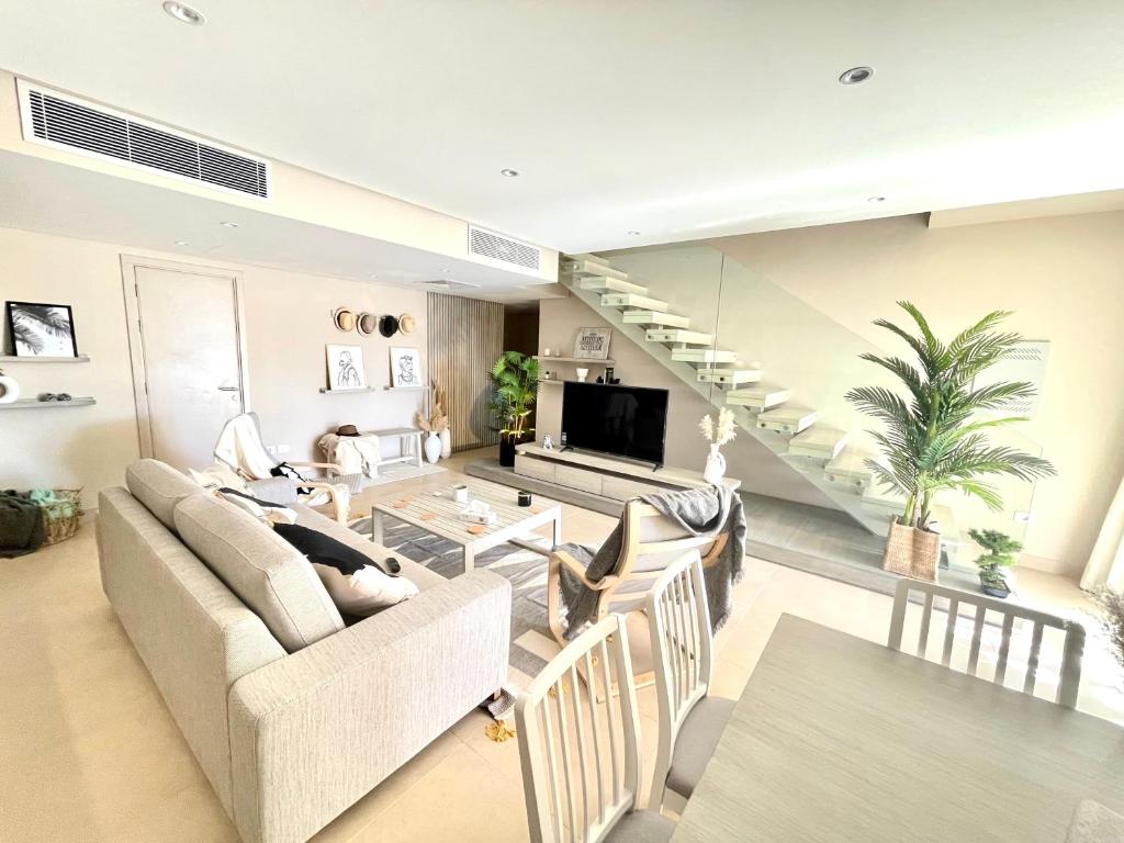 ein Wohnzimmer mit 2 Sofas und einer Treppe in der Unterkunft A Stunning Seaview Penthouse; 3bedrooms + nanny in Hurghada
