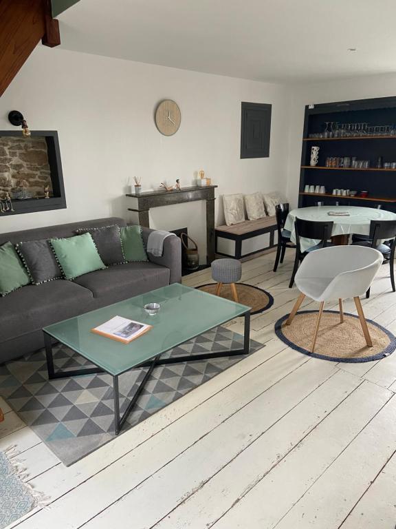 uma sala de estar com um sofá e uma mesa em Charmant appartement 4 pers au centre des remparts em Guérande