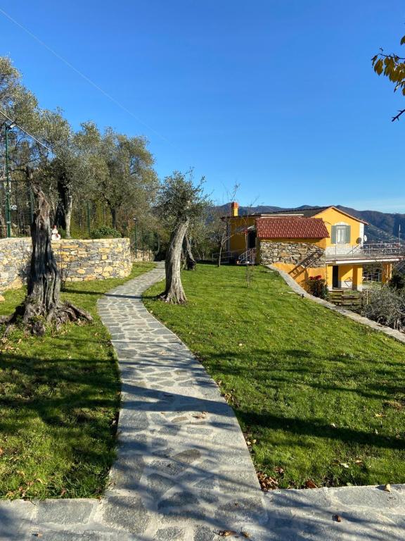 einen Gehweg in einem Park mit Bäumen und einem Haus in der Unterkunft Sunrise Holiday Home in Camogli