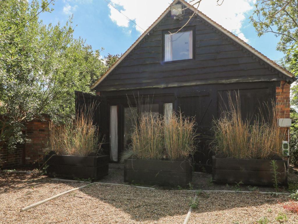 une maison avec deux plantes devant elle dans l'établissement Broadford Barn - Barn conversion in picturesque village, à Shalford