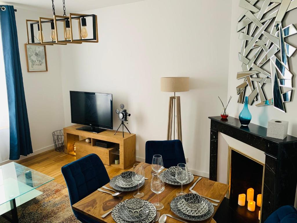 - un salon avec une table et une cheminée dans l'établissement Nice cocooning apartment for a relaxing moment, à Reims