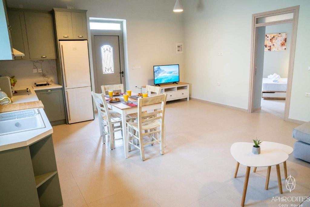 cocina y sala de estar con mesa y sillas en Aphrodite’s Cozy House, en Kolimvárion