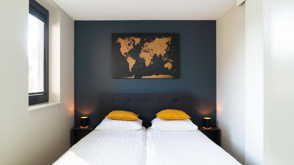 een slaapkamer met 2 bedden en een kaart aan de muur bij Strand, Zee & Meer in Vrouwenpolder